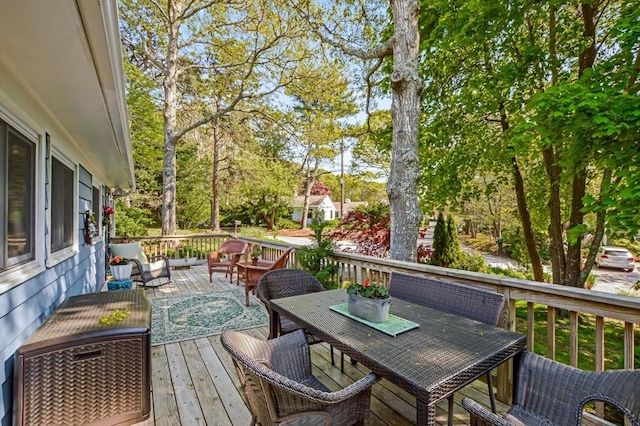 wooden terrace featuring an outdoor hangout area, outdoor dining area, and view of scattered trees