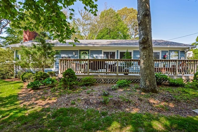 view of front facade featuring a wooden deck and a chimney