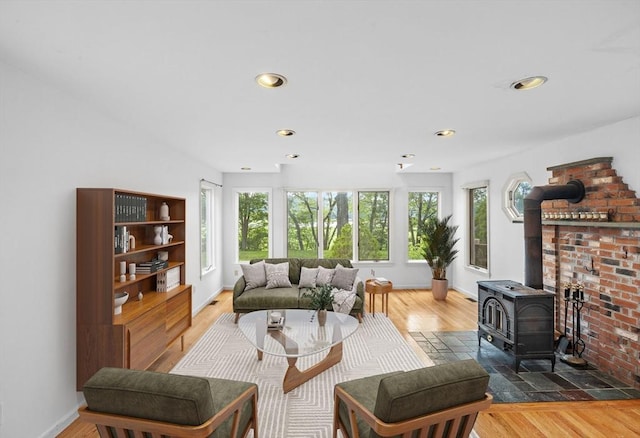 94 Clinton Rd, Weymouth, MA 02189 - living area with healthy amount of natural light, a wood stove, recessed lighting, and wood finished floors