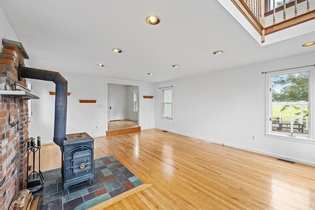 94 Clinton Rd, Weymouth, MA 02189 - unfurnished living room with a wood stove, wood finished floors, and recessed lighting