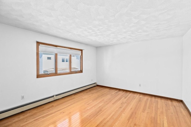 unfurnished room featuring light wood-type flooring, baseboards, baseboard heating, and a textured ceiling