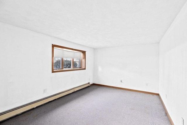 spare room featuring a baseboard radiator, light carpet, and baseboards