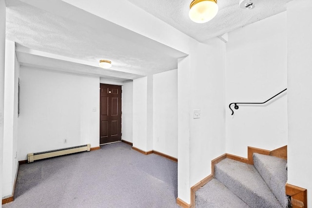 below grade area featuring a baseboard heating unit, a textured ceiling, stairs, and baseboards