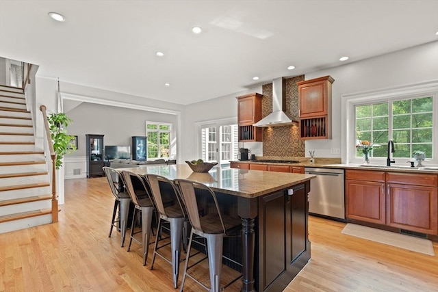 45 Anselm Way, Sudbury, MA 01776 - kitchen featuring dishwasher, wall chimney exhaust hood, a center island, light wood-style floors, and a kitchen breakfast bar