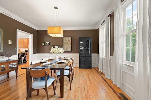 45 Anselm Way, Sudbury, MA 01776 - dining area with ornamental molding, light wood-style flooring, a wainscoted wall, and a decorative wall