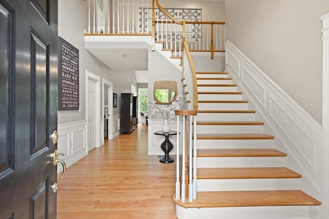 45 Anselm Way, Sudbury, MA 01776 - foyer with a decorative wall, stairway, a high ceiling, light wood finished floors, and wainscoting