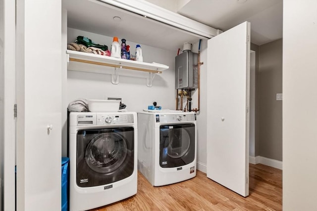 5 Brigham St Unit 1, Boston, MA 02128 - laundry room with tankless water heater, washer and clothes dryer, light wood-style floors, and baseboards