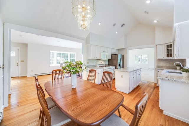18 Curve Hill Rd, Yarmouth, MA 02664 - dining space featuring baseboard heating, light wood finished floors, a chandelier, high vaulted ceiling, and recessed lighting