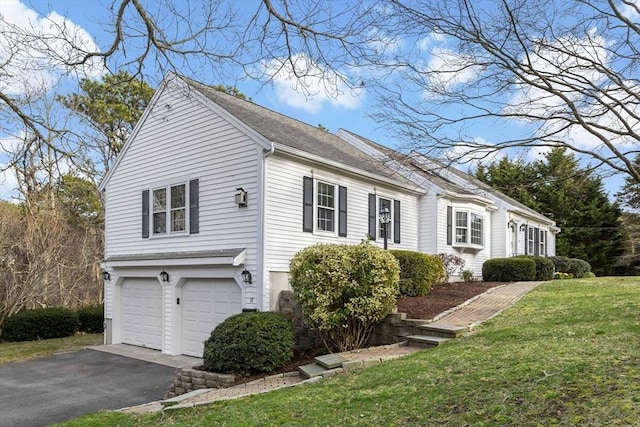 18 Curve Hill Rd, Yarmouth, MA 02664 - view of side of home with an attached garage, driveway, and a yard