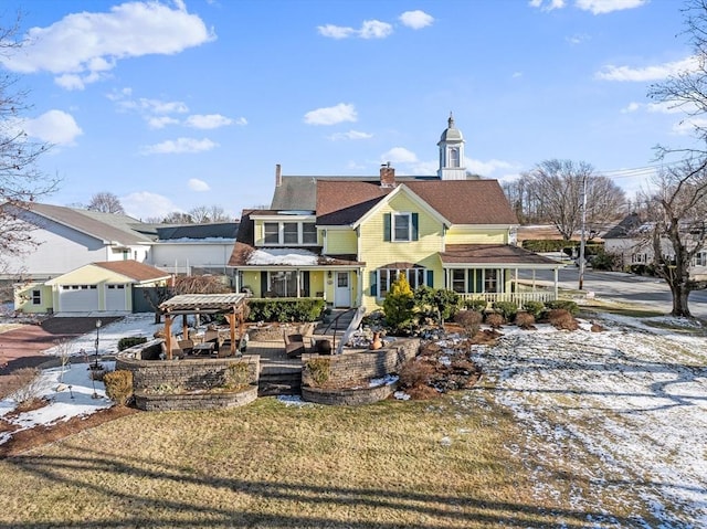 back of property with covered porch, a yard, and a garage