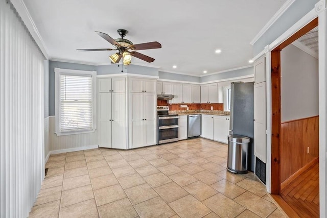 kitchen with crown molding, ceiling fan, light tile patterned floors, appliances with stainless steel finishes, and white cabinetry