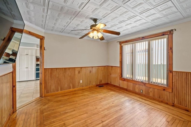 unfurnished room with ceiling fan, crown molding, and light hardwood / wood-style floors