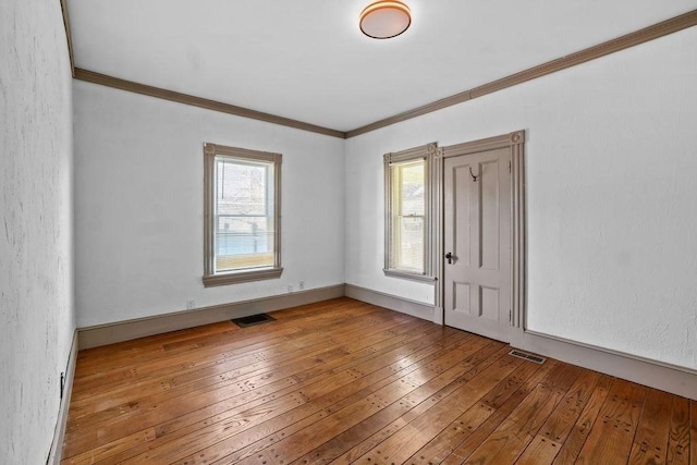 spare room with wood-type flooring and ornamental molding