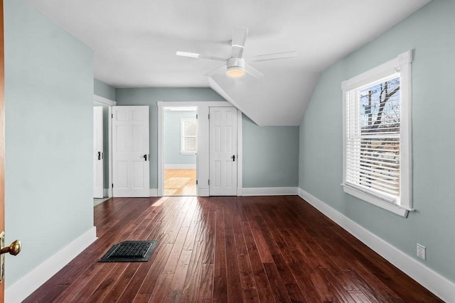 additional living space with dark hardwood / wood-style floors, vaulted ceiling, and a healthy amount of sunlight