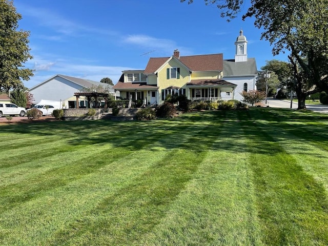 rear view of house featuring a lawn