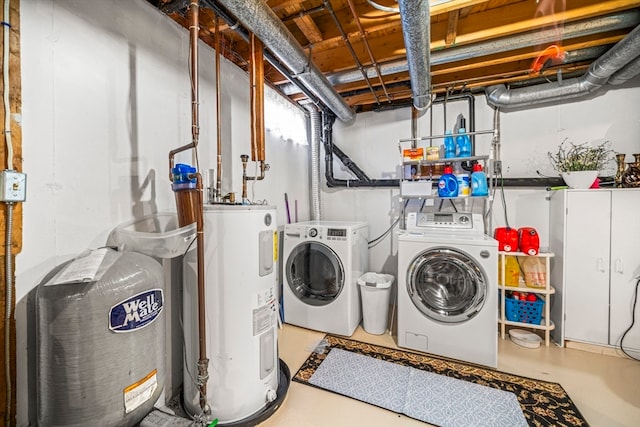 washroom with washing machine and clothes dryer and water heater