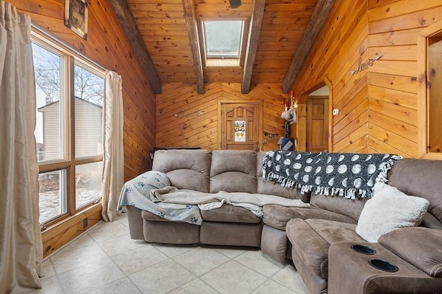 living area featuring wood ceiling, vaulted ceiling with skylight, a healthy amount of sunlight, and wood walls