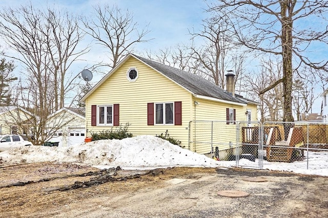 view of front of home featuring a gate, fence, and a chimney