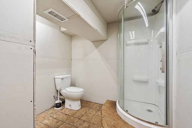 bathroom featuring visible vents, toilet, and a stall shower