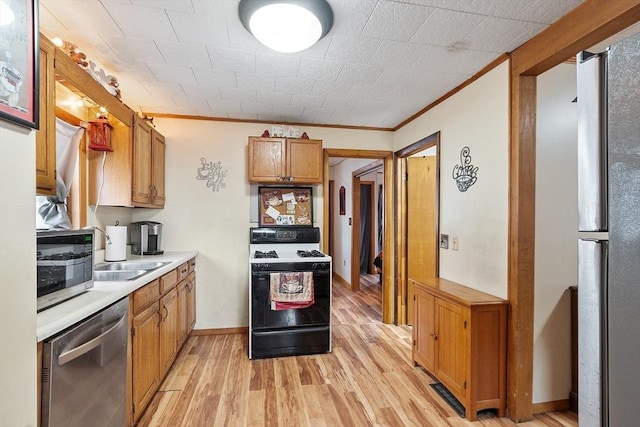 kitchen with baseboards, light countertops, ornamental molding, light wood-style flooring, and stainless steel appliances