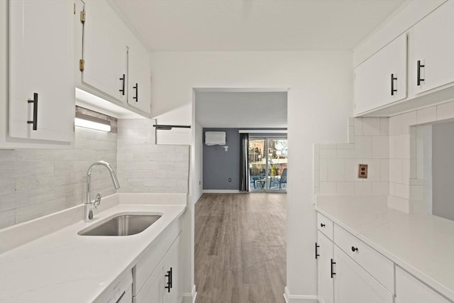 kitchen with white cabinetry, light wood-style floors, and a sink