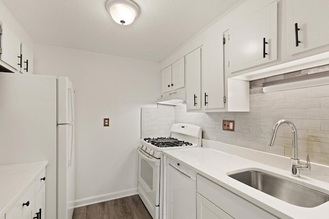 kitchen featuring backsplash, under cabinet range hood, white cabinets, white appliances, and a sink