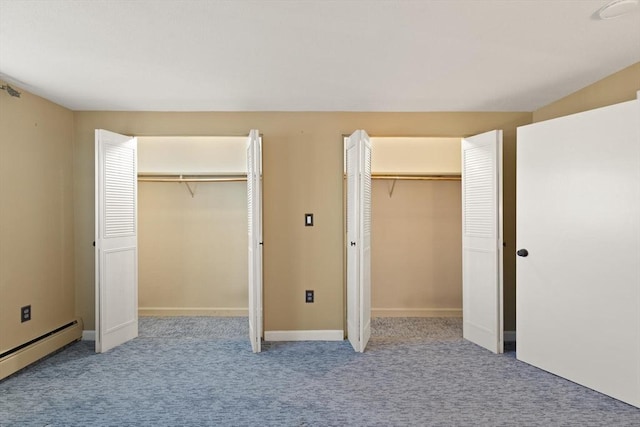 unfurnished bedroom featuring light colored carpet, multiple closets, and a baseboard radiator