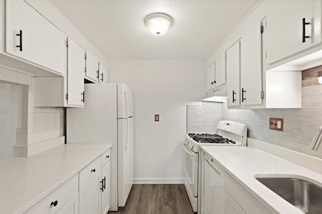 kitchen featuring white appliances, a sink, decorative backsplash, under cabinet range hood, and white cabinetry