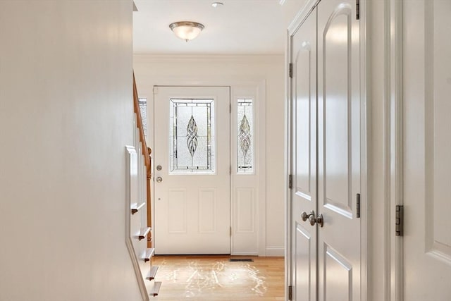 doorway to outside with light wood-type flooring and ornamental molding
