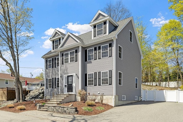 view of front of property featuring driveway and fence