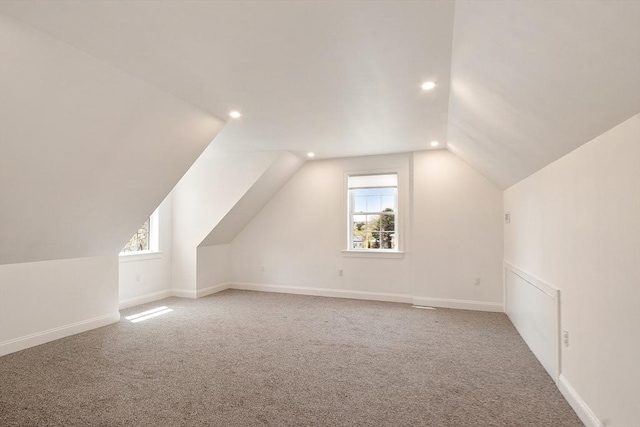 additional living space with recessed lighting, a wealth of natural light, carpet, and vaulted ceiling