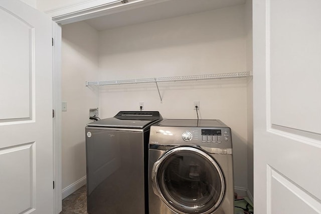 laundry area featuring separate washer and dryer, laundry area, and baseboards