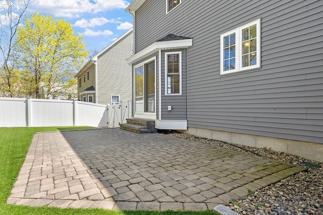 back of property with fence and a patio
