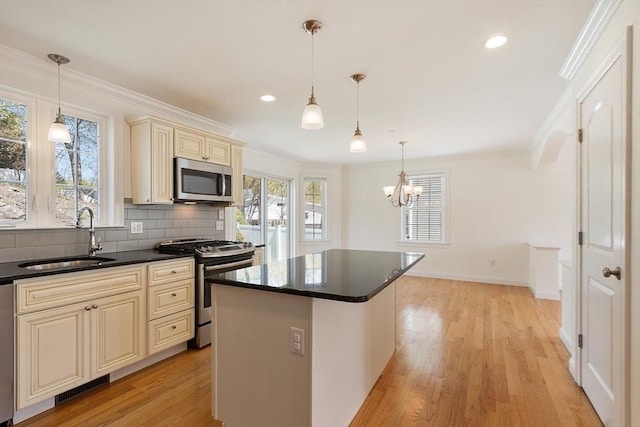 kitchen featuring plenty of natural light, cream cabinetry, appliances with stainless steel finishes, and a sink
