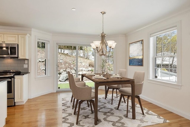 dining room with ornamental molding, light wood-type flooring, a notable chandelier, and baseboards
