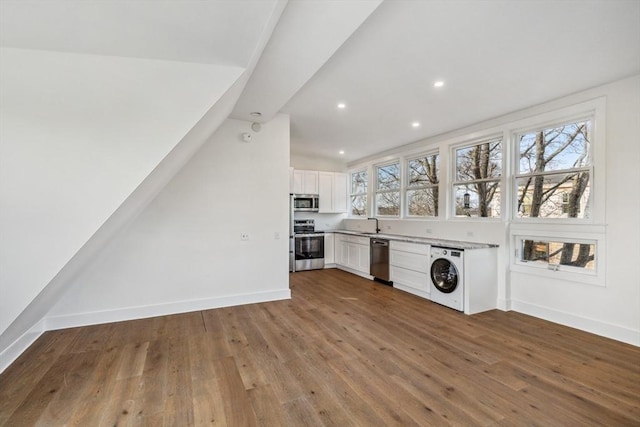 washroom with hardwood / wood-style flooring, washer / dryer, and a wealth of natural light