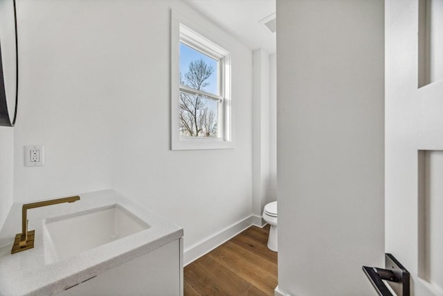 bathroom featuring hardwood / wood-style flooring, vanity, and toilet