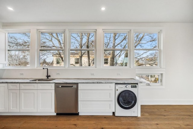 laundry area with hardwood / wood-style flooring, washer / clothes dryer, and sink