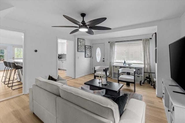 living room with light hardwood / wood-style flooring and ceiling fan