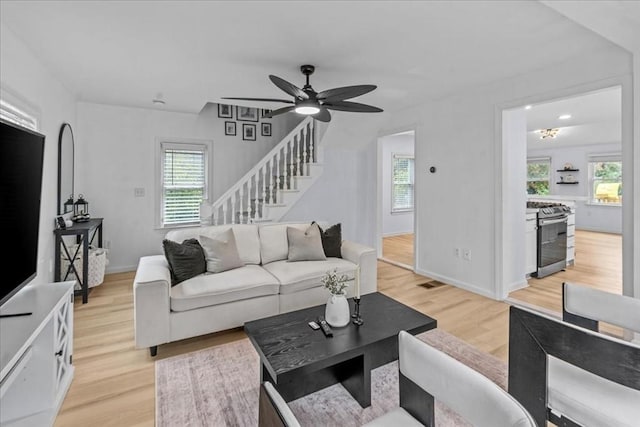 living room featuring ceiling fan and light hardwood / wood-style flooring