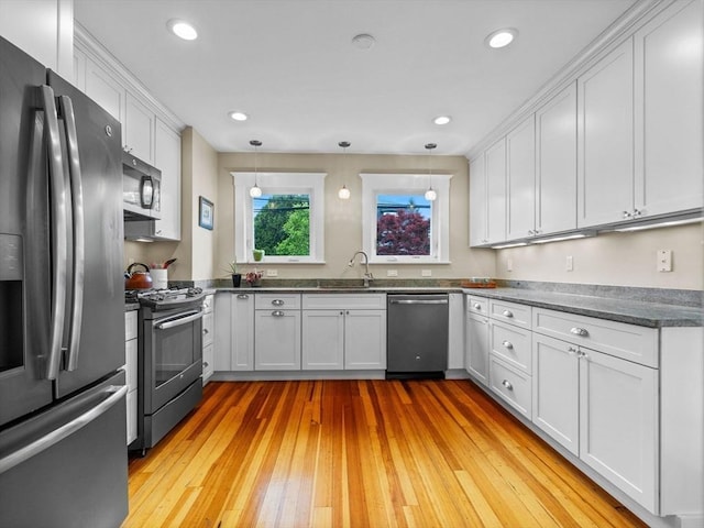 28 Albano St, Boston, MA 02131 - kitchen featuring appliances with stainless steel finishes, white cabinets, light wood finished floors, pendant lighting, and recessed lighting