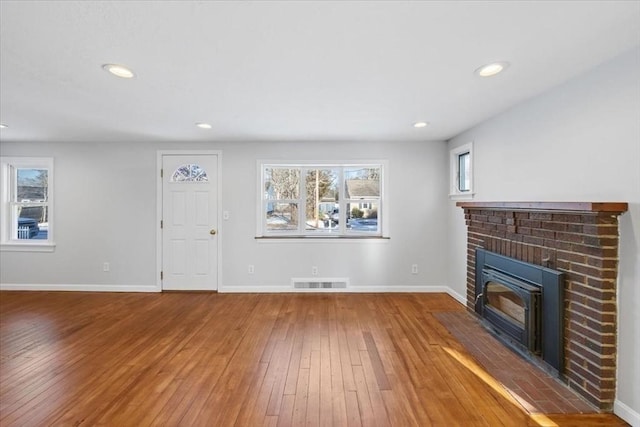 unfurnished living room with wood-type flooring and a fireplace