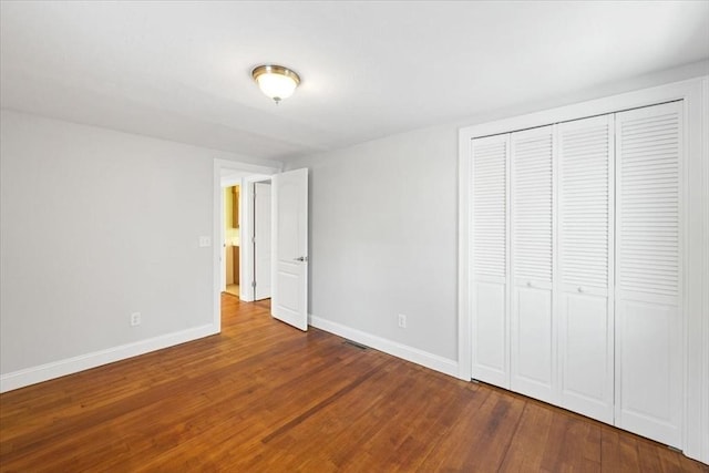 unfurnished bedroom featuring hardwood / wood-style flooring and a closet