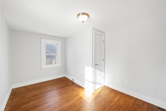 empty room with hardwood / wood-style floors