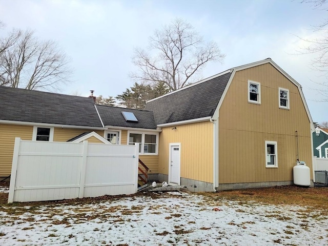 snow covered back of property featuring cooling unit