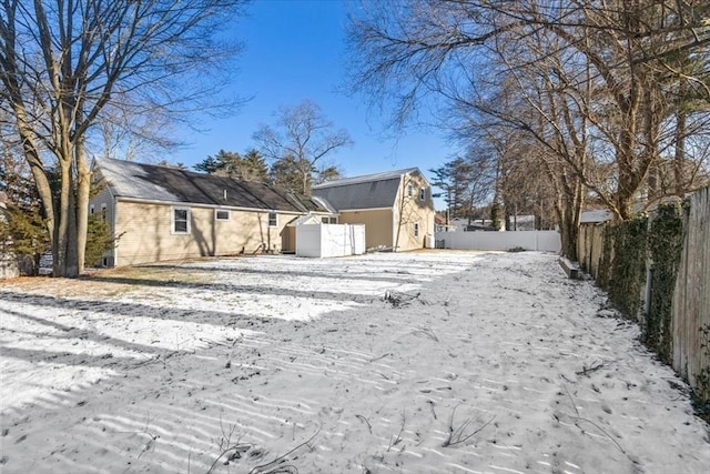 view of snow covered back of property