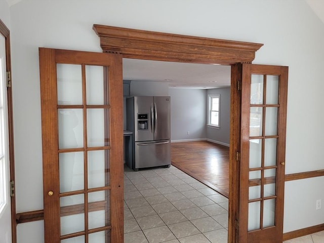 kitchen with stainless steel refrigerator with ice dispenser, light tile patterned flooring, and french doors