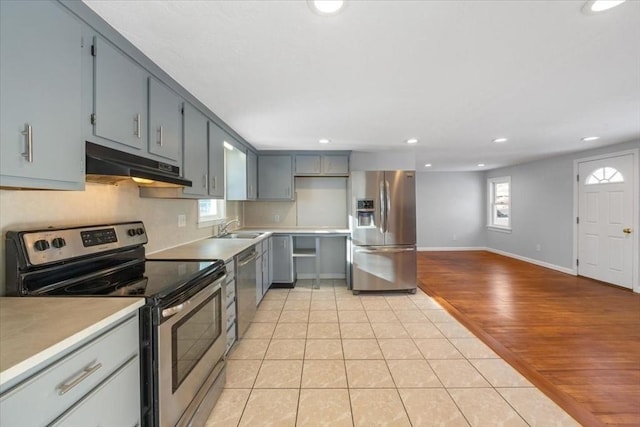 kitchen featuring gray cabinetry, appliances with stainless steel finishes, sink, and light tile patterned floors