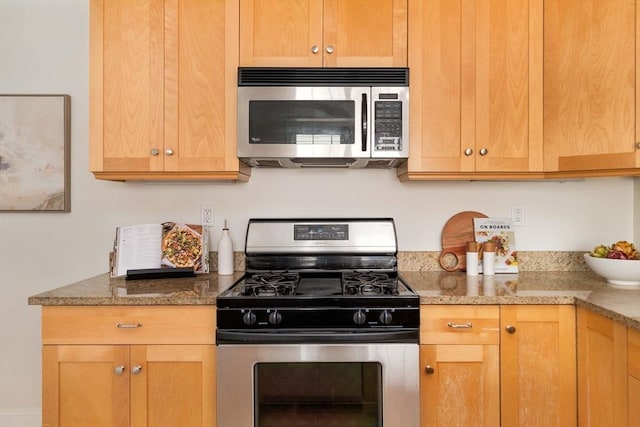 kitchen featuring stainless steel appliances and light stone counters