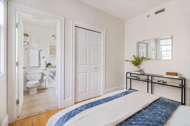 tiled bedroom featuring ensuite bathroom